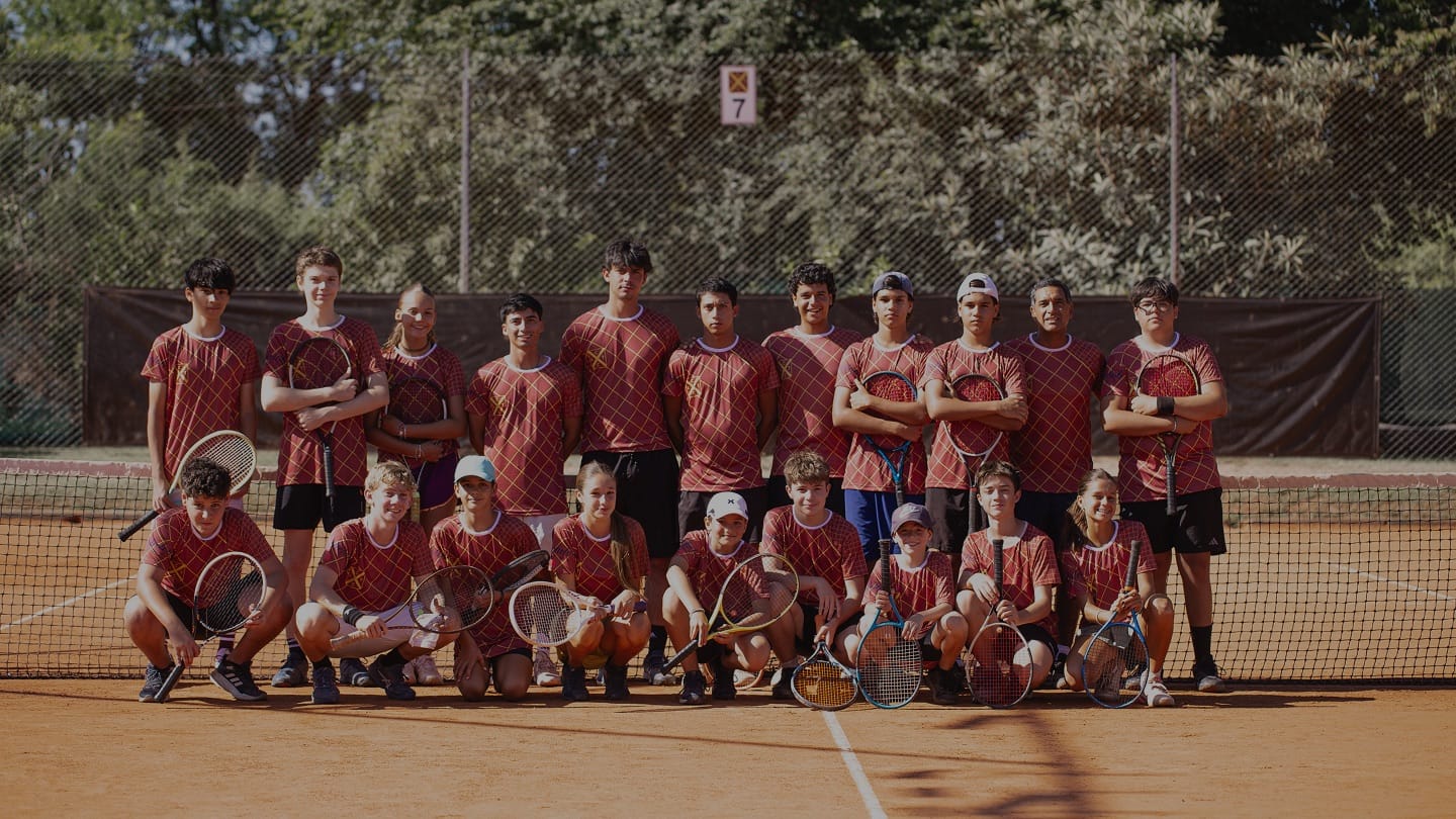 Chicas y chicos de la escuela de verano jugando al tenis